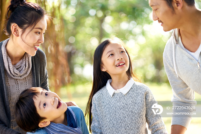 asian family with two children having fun in park