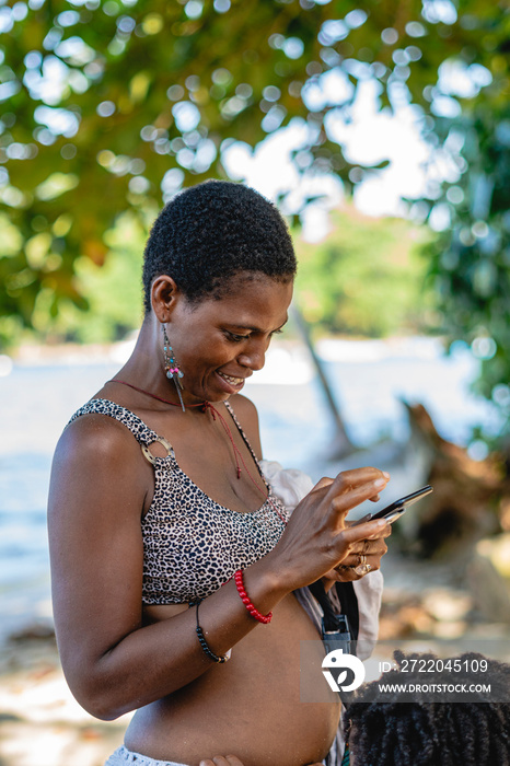 Imagen vertical de una mujer africana de cabello afro corto sonriente al aire libre en un día de ver