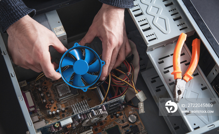 Man repairs cooling system of computer.