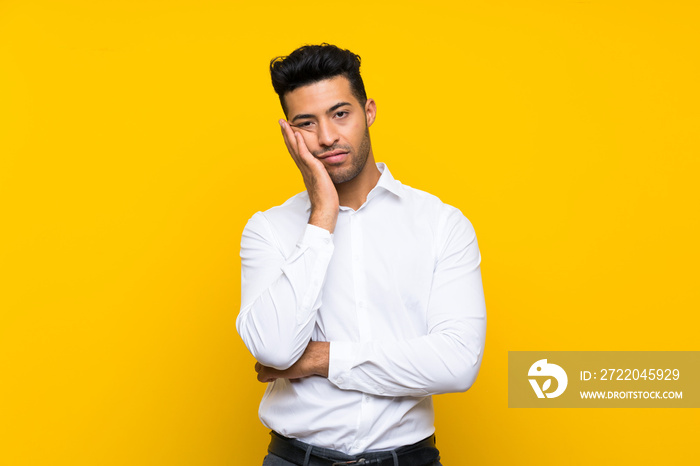 Young handsome man over isolated yellow background unhappy and frustrated