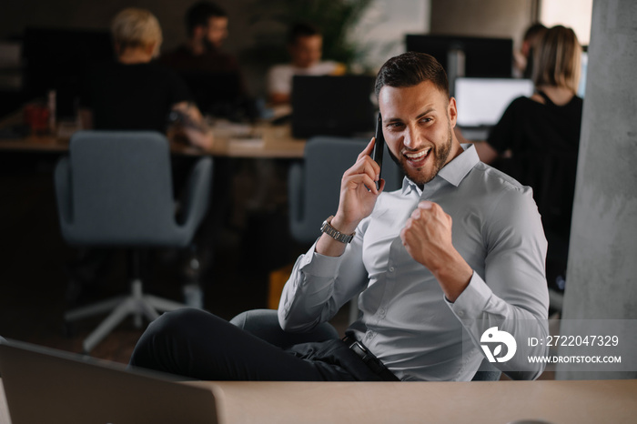 Handsome businessman celebrating won. Portrait of businessman in office.