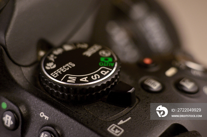 Close-up macro shot of a modern digital SLR camera. Detailed photo of black camera body with a class