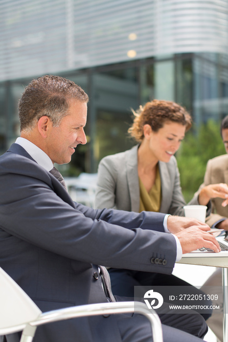 Businessman using laptop at outdoor cafe