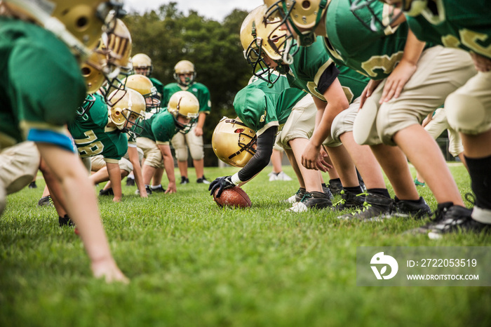 Boys playing American football in field