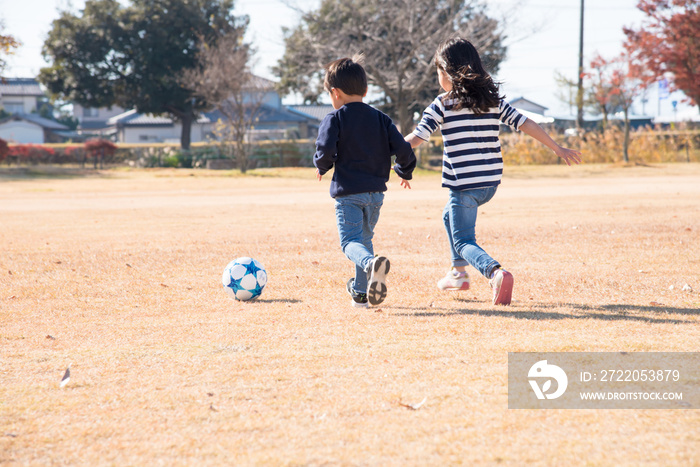 公園でサッカーをする子供