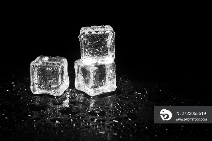 ice cubes reflection on black table background.