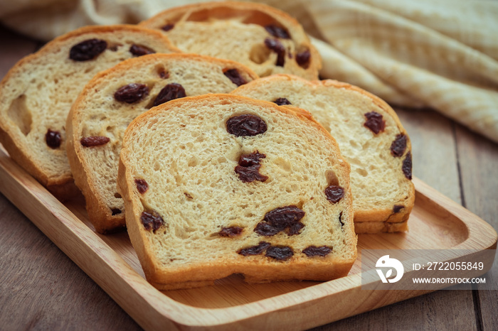 Sliced raisin bread on wooden plate