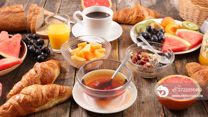全套早餐，包括咖啡杯、茶杯、羊角面包、面包和水果
