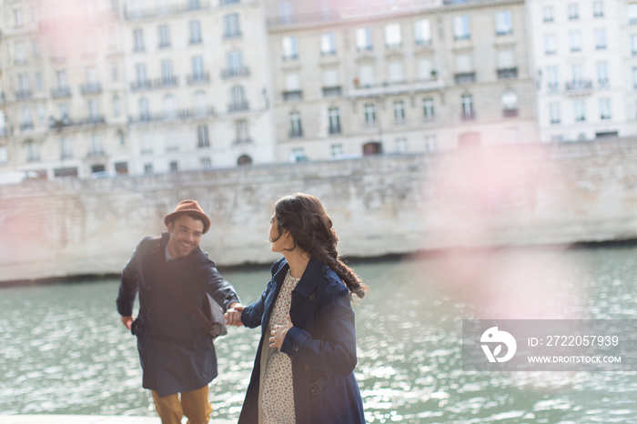 Affectionate couple holding hands at Seine River, Paris, France