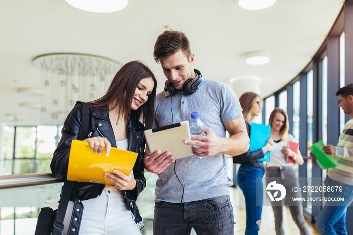 Two students using they digital tablet in a university.