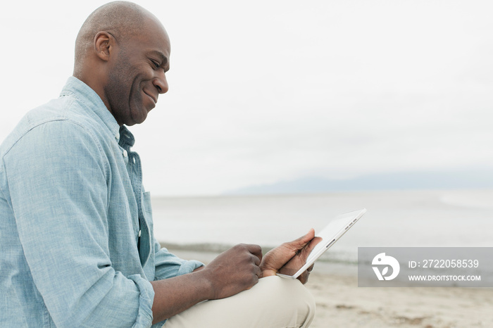 African American man using pc tablet by the waterfront