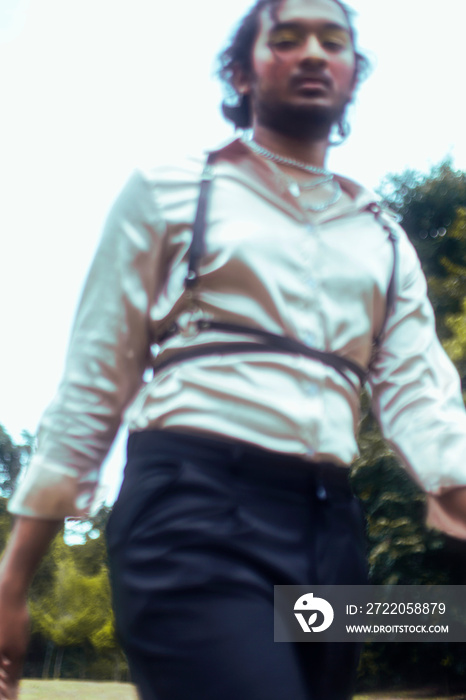 dreamy portrait of a dark skinned Indian man in Malaysia, with make up, in a field, surrounded by na