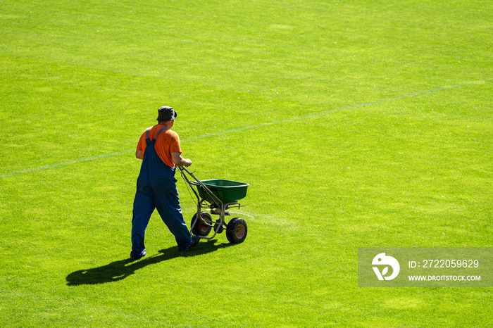 场地管理员在足球场上为草地施肥