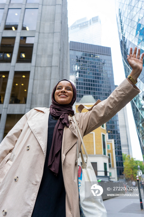 Woman wearing�hijab�hailing taxi