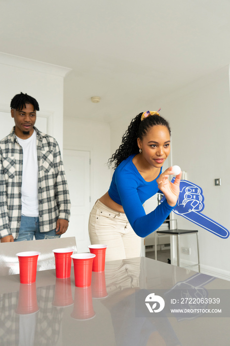 Friends�playing beer pong at home party