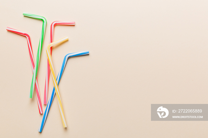 Drinking straws for party on Colored background. Top view of colorful plastic disposable straws for 