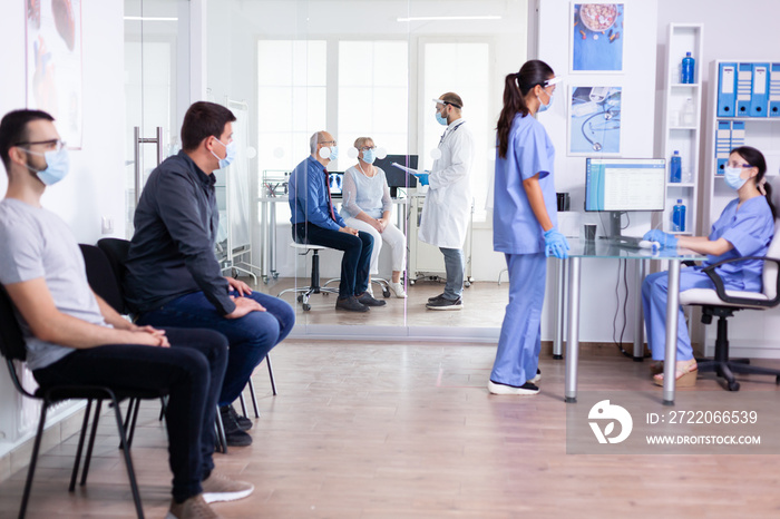 Nurses wearing face mask against coronavirus and having a conversation on hospital waiting area. Ass