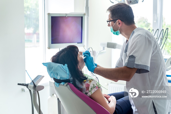 Dentist examining patient teeth with intraoral camera