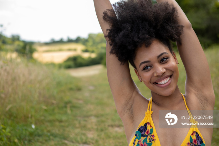 Portrait of young�woman stretching in meadow