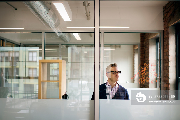 Businessman looking at text on glass in office