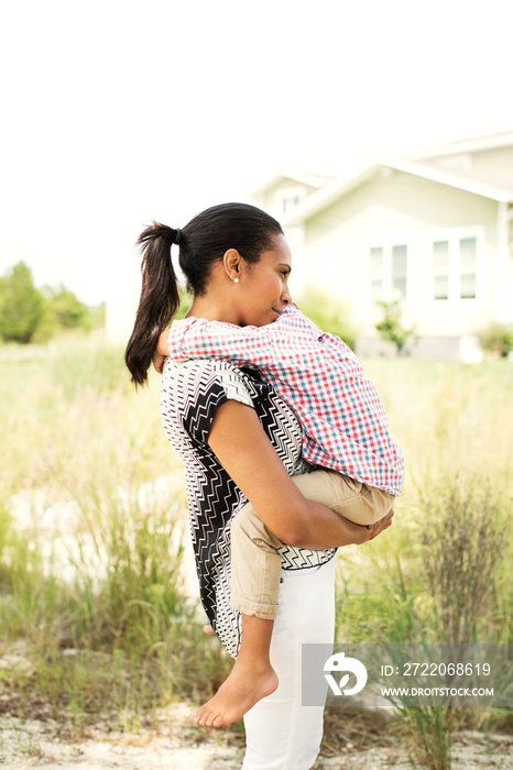 Woman embracing her son (2-3) in backyard