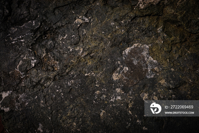 Rough cave stone wall surface with natural cracks used for background.