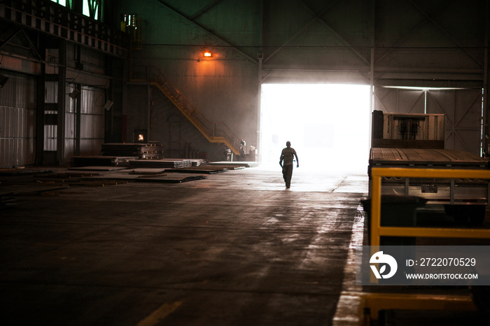 Silhouette of man walking in warehouse