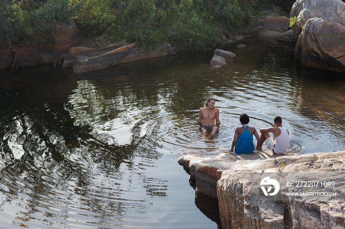 Young friends swimming and relaxing at lake