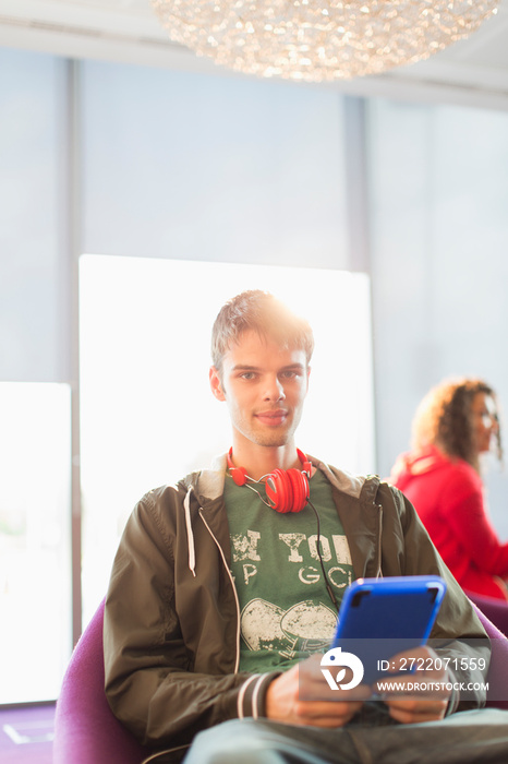 用数字平板电脑拍摄戴着耳机的年轻人肖像