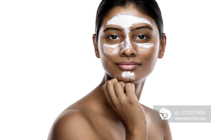 Young indian woman with a cleansing mask applied on her face