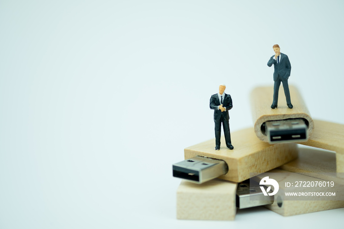 Miniature people businessman standing on wooden USB stick. Analysis data concept