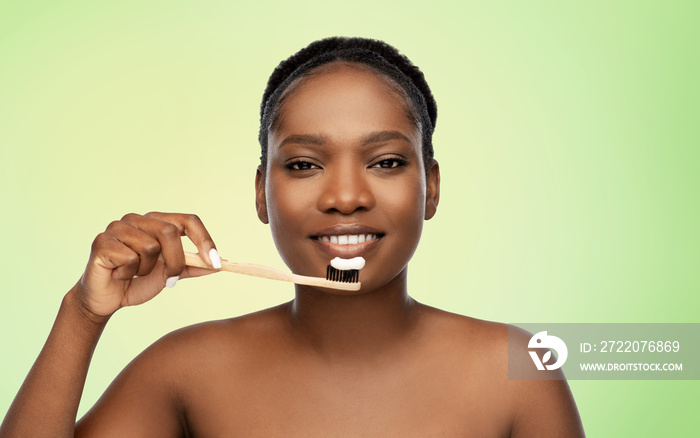 beauty and people concept - close up of of happy smiling young african american woman cleaning teeth