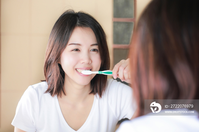 年轻女子对着镜子刷牙。醒来后