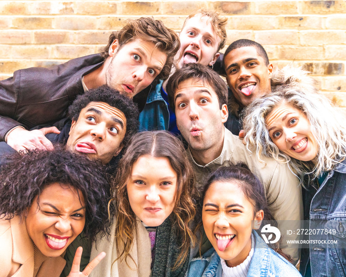 Multiracial friends taking selfie and making funny faces