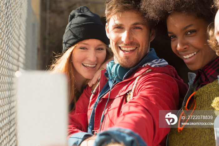 Happy young friends taking selfie with smart phone