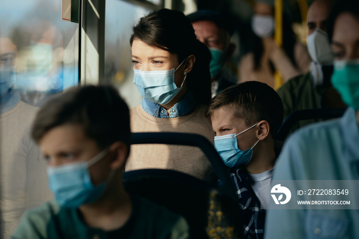 Mother and son wearing face masks while traveling by public transport.