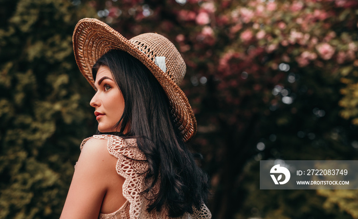 Exquisite woman with perfect skin near flowering tree