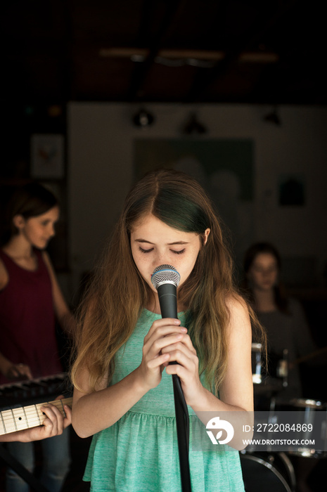 Girls (10-11,  12-13) singing and playing instruments