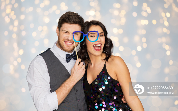 庆祝、娱乐和节日概念-幸福的夫妇戴着派对眼镜在节日灯光下摆姿势b