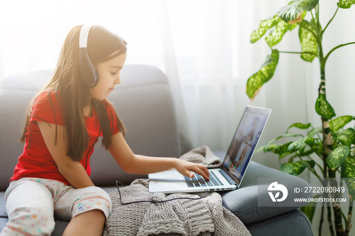 Pretty stylish schoolgirl studying homework math during her online lesson at home, social distance d