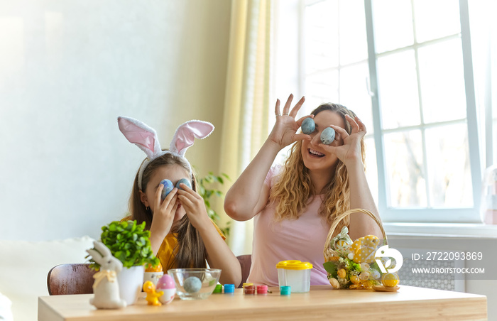 Happy family holding easter eggs to close their eyes