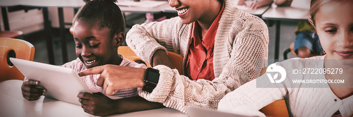 Teacher helping student with tablet computer