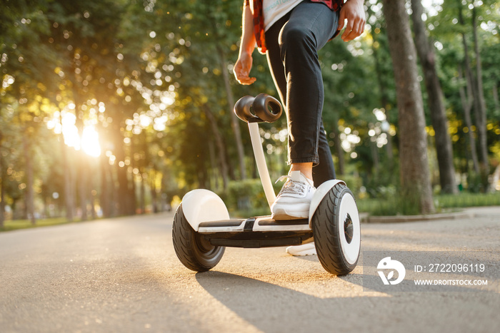 Young male person riding on gyroboard in park