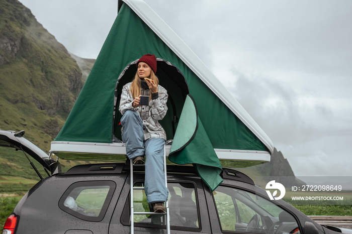 Woman putting at the pause her journey and eating sandwiches with tea at the tent