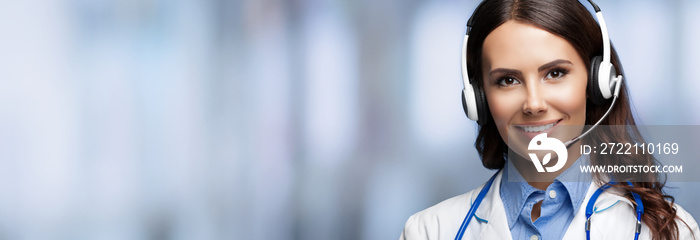 Medical call center servise. Online helping and consultation. Portrait of female doctor in headset, over blurred office background, with copy space empty place for some sign text or slogan.