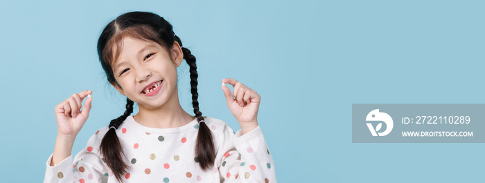 7 Years old child has loose tooth, Dentistry and Health care concept, Empty space isolated on blue background