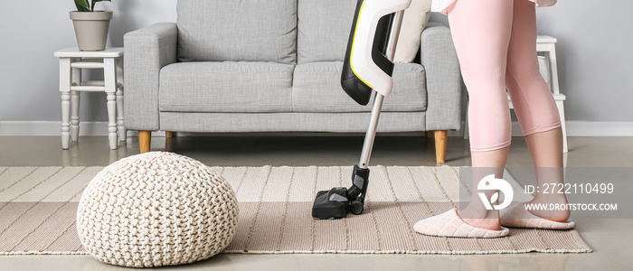 Woman vacuuming carpet in living room