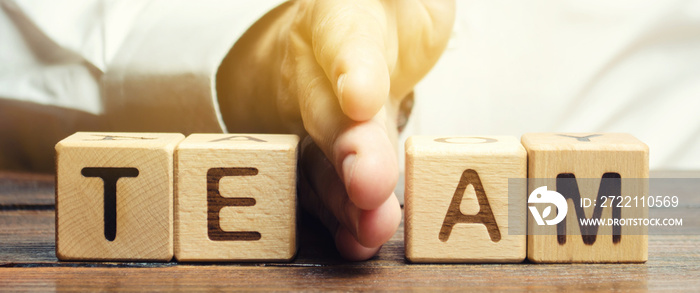 A businessman divides the word Team into two parts. Small grouping. Employee management. Working staff. The organization of the team. The division of work. Efficiency. Separation of powers