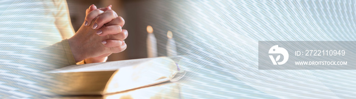 Woman praying with her hands over the bible, hard light. panoramic banner