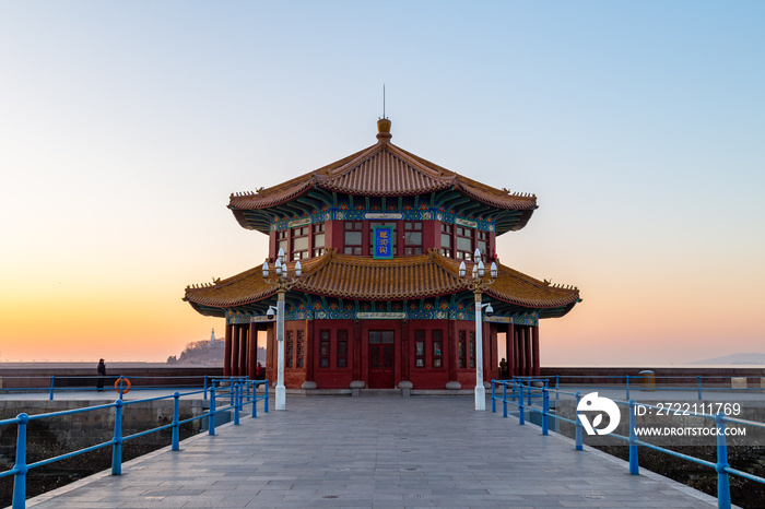 Zhanqiao pier at sunrise, Qingdao, Shandong, China. The name  Huilan Pavilion  is engraved above the entrance door.